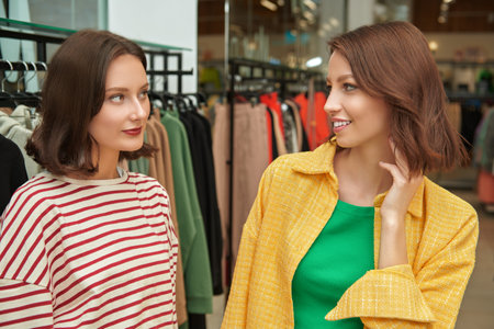 Portrait of two pretty girls friends in a clothing shop. Girls on shopping.