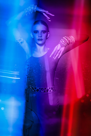 Gorgeous female dancer performs latino dance in elegant dress with sparkling jewelry. Fashion and...