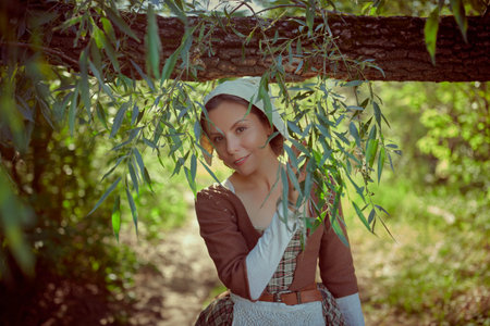 A cute medieval girl in a Scottish dress of the 18th century walks peacefully through the summer...