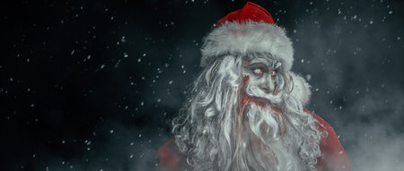 A portrait of a scary zombie Santa Claus, who stands in the night under the snowfall and smiles. Nightmare at Christmas. Halloween. Copy space.の写真素材