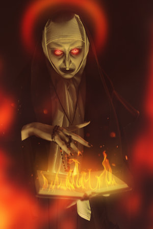 An evil cursed nun with a burning bible and a cross in her hands looks at the camera on a black background with red glow. Halloween. Horrors.の写真素材