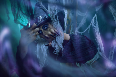 A scary ugly witch stands in an abandoned witch's den. Halloween. Scary tales.の写真素材