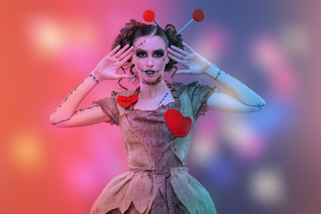 Halloween. Portrait of a pretty girl in a dress and with a make-up and hairstyle of a voodoo doll on...