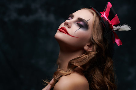 Beauty and Horror. Portrait of a beautiful and scary young clowness against a dark vintage...