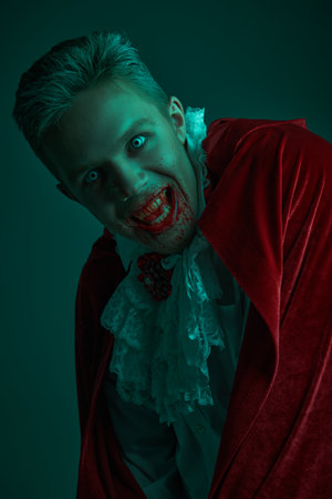 Vampires. Portrait of an evil vampire man in an elegant 19th century suit shouting in a rage on a dark background. Halloween.の写真素材