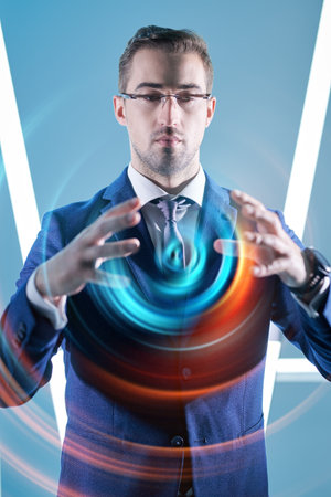 Business technologies of the future. A business analyst works with a 3D-hologram. Light blue background with neon lamps.の写真素材