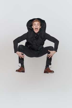 People, emotions. Funny excited young man makes a high jump. Splash out emotions. Studio full-length...
