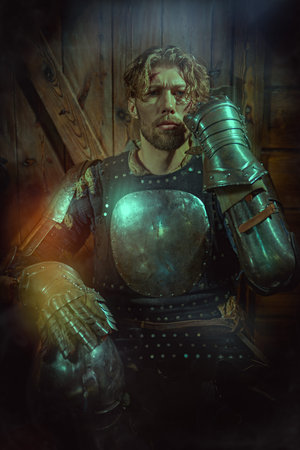 A handsome noble medieval knight in armor stands in a castle and looks forward courageously. Fantasy. Tales of knights. Historical reconstruction.の写真素材