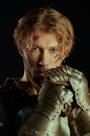 Portrait of a handsome medieval knight with scars on his face in armor, menacingly and boldly...
