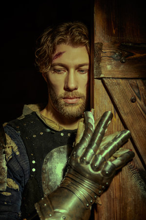 A handsome noble medieval knight in armor standing in a castle. Tales of knights. Fantasy. Historical reconstruction.の写真素材