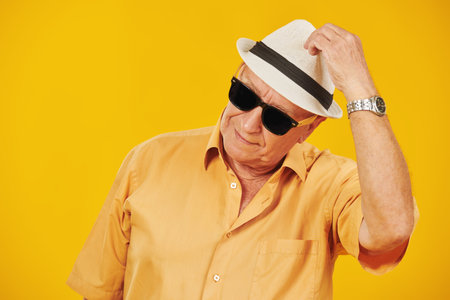 Retirement age. Shot of an old elegant man in summer clothes and sunglasses looking cool. Yellow...