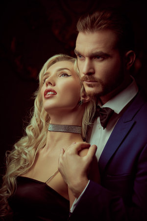 Sexy elegant couple. Beautiful blonde woman in evening black dress leaning against her handsome man. Evening Fashion.の写真素材