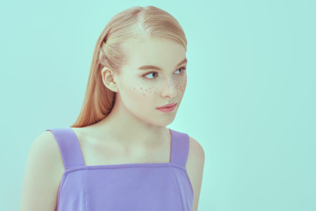 Beautiful tender girl with fresh shiny skin, light makeup with glitter freckles and long fair hair...
