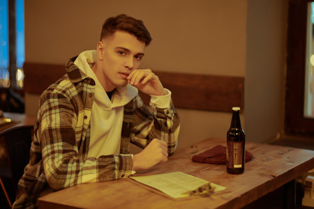 A shot of a modern young man spending time in a bar drinking beer. Free time, lifestyle.の写真素材