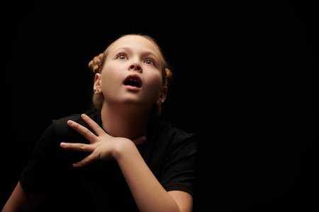 Little actress. Portrait of a girl artistically posing against a black studio background. Copy...