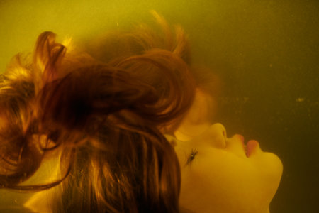 Water art fantasy. Close-up of a beautiful girl with long hair underwater. Weightlessness, feeling of flight.の写真素材