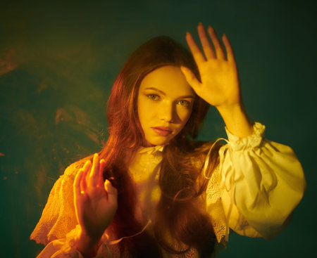 Art portrait of a beautiful tender girl in a vintage white dress, who is looking at the camera,...