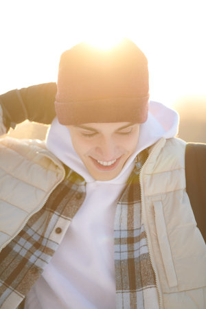 Emotions. Happy people concept. Portrait of a handsome happy guy in winter clothes who is standing...