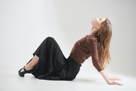 Modern dance style. Young dancer girl posing at the studio on a white background. Full-length portrait.の写真素材
