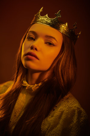 Portrait of a beautiful proud medieval princess. Dark red studio background. Fairytale princess. Fantasy.の写真素材