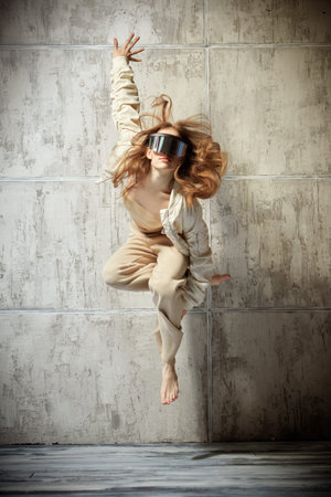 Modern style dancer girl jumping against a grunge studio background. Contemporary dances.