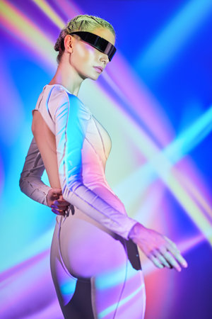 Virtual reality games. Perfect cyber girl in futuristic glasses and overalls  standing among laser neon beams. Cyberspace. Digital technologies of the future.の写真素材