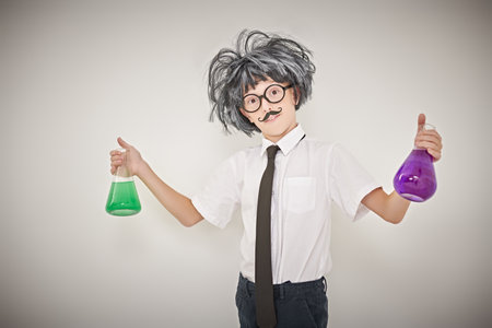 Young chemist. A smart child boy is experimenting with flasks in the laboratory. White background with copy space. Educational concept.の写真素材