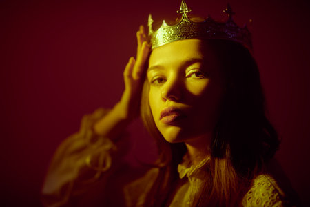 Shot of a beautiful proud medieval princess. Dark red studio background. Fairytale princess. Fantasy.の写真素材