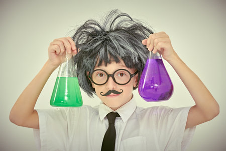 Young chemist. A smart child boy is experimenting with flasks in the laboratory. White background. Educational concept.の写真素材