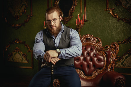 Successful businessman. Handsome well-groomed male gentleman in a classic respectable suit with a vest and shirt in a luxury interior. Men's hairstyles and beard. Male beauty and fashion.の写真素材