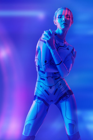 Futuristic space style. Virtual cyberspace. A beautiful cyberpunk girl in a tech jumpsuit standing in neon blue light.の写真素材