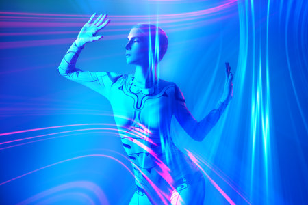 VR games. Perfect cyber girl in futuristic overalls stands in the light of digital hologram and neon rays. Cyberspace. Digital technologies of the future.の写真素材