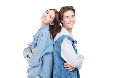 Denim fashion, teenage style. Shot of smiling teen boy and girl in trendy denim clothes posing on a white background.の写真素材