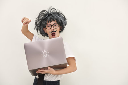 Cute little kid in glasses, with a mustache and in a wig, holds a laptop and like little professor...