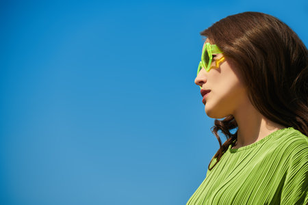 A beautiful Asian young woman is walking in a summer park against the backdrop of blue sky. Happy sunny day. Summer rest. Place for text.の写真素材