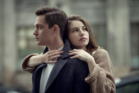 Young people and relationships. Happy young couple in love hugging each other while standing on the city street. Walk on a cloudy day. Love story.の写真素材