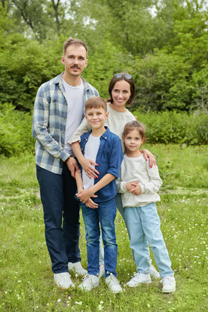 A happy family. A cheerful friendly family of parents and two children walk in the summer park. Summer time and holidays.の写真素材