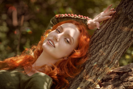 Historical reconstruction of ancient Celtic times. Beautiful red haired girl in a traditional green...