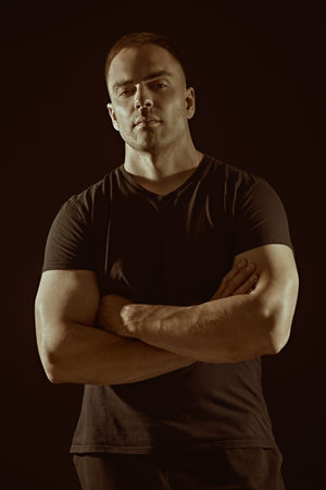 Athlete, bodybuilder. A strong man looks at the camera confidently. Studio portrait on a black...