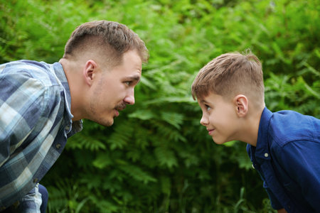 Friendly dad and son play in a summer park. A happy friendly family. Summer time and holidays.の写真素材