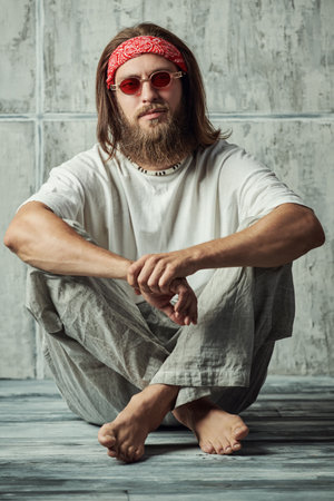 Rastaman hippie guy catches his zen while sitting relaxed. Full-length portrait.の写真素材