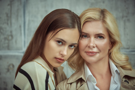 Happy beautiful elderly mother and her adult daughter. Family relationships. Studio portrait.の写真素材