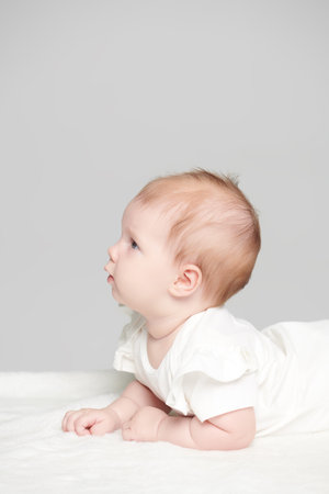 Portrait of a cute newborn baby. Gray studio background. Place for text.の写真素材