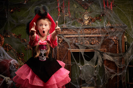 Halloween party at the haunted castle. A pretty girl in a pirate costume is very surprised, showing thumbs up. Place for text.の写真素材
