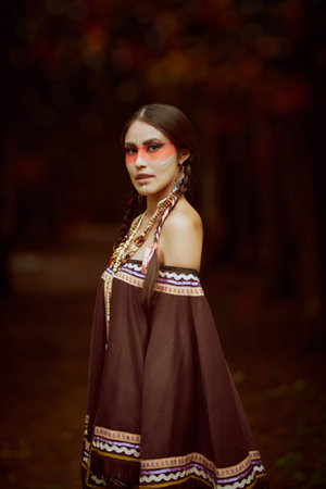 Native Americans. Retro portrait of an American Indian girl in national dress and jewelry on a dark...