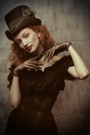 Portrait of a pretty and confident adventurous girl with bright red hair, dressed in an elegant...
