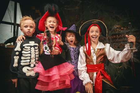 Halloween party. Cheerful emotional children in carnival costumes celebrate Halloween in a haunted castle.の写真素材