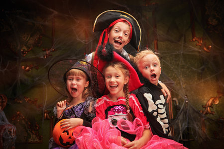 Cheerful emotional children in carnival costumes celebrate Halloween in a haunted castle. Halloween party.の写真素材
