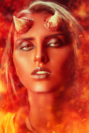 Close-up portrait of a magnificent and terrible devil girl with bloody horns, surrounded by...