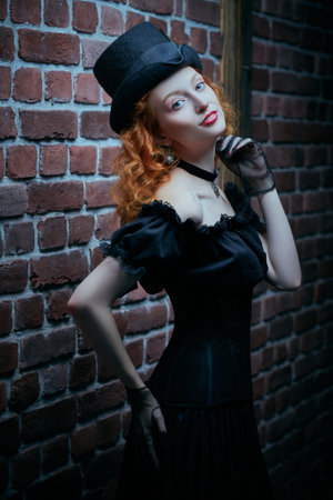 An attractive young lady with curly red hair, dressed in an elegant black cut-out dress and a felt...